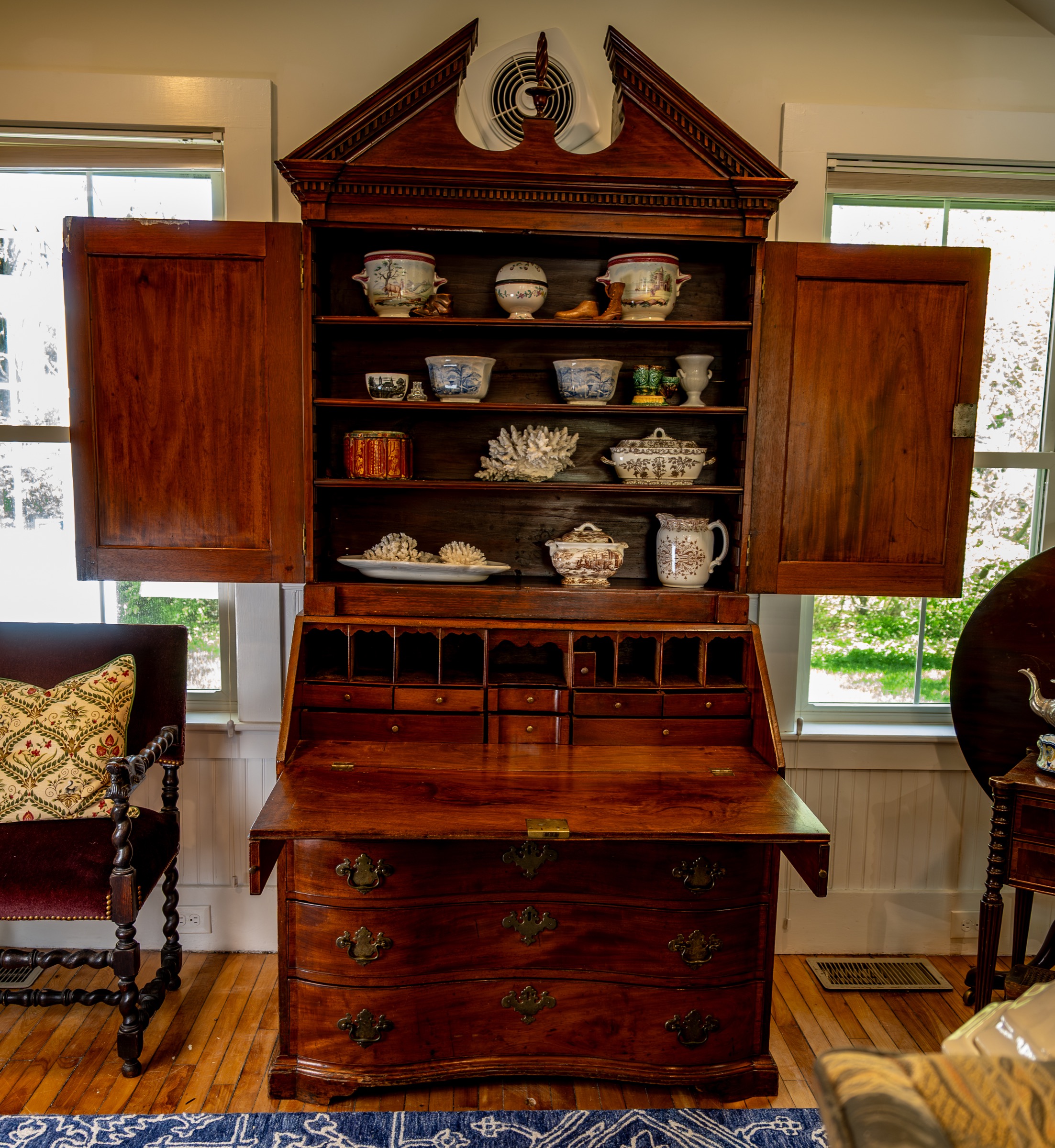 Antique secretary desk with ceramics and decorative objects.